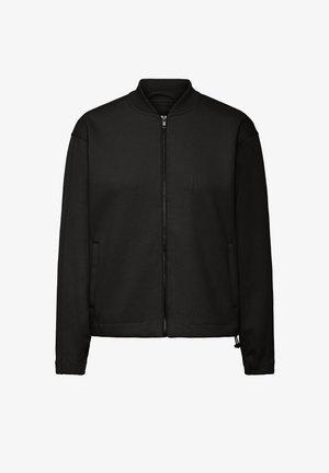 Must värvi bombertagi, mis on valmistatud siledast kangast, millel on soonikkoes krae, tõmbluku sulgemine, küljetaskud ja elastsed mansetid. Minimalistlik disain.