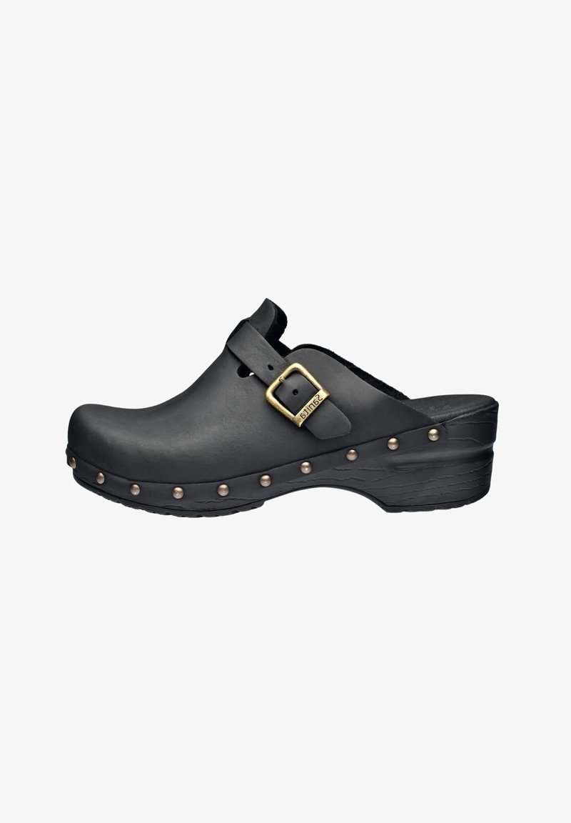 Zoccolo nero in pelle liscia con punta rotonda, dotato di una fibbia laterale e borchie decorative in ottone lungo il bordo inferiore.