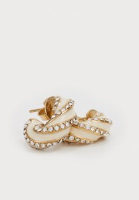 Gouden gedraaide oorbellen met een crèmekleurige emaille afwerking en duidelijke rhinestones langs de randen, wat zorgt voor een textuurrijke, gelaagde uitstraling.