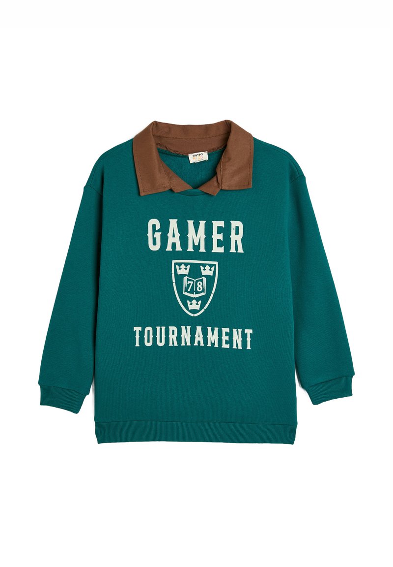Teal sweatshirt med brun krage och långa ärmar. Har texten "GAMER TOURNAMENT" och en sköldgrafik med kronor. Bomullstextur.