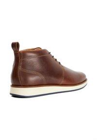 Brown leather ankle boots with smooth texture, featuring a white rubber sole, brown laces, and a small rear pull tab.