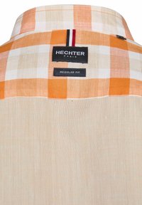 Korte mouwen geruite shirt in oranje en crème met een reguliere pasvorm; heeft een soepele textuur en merknamen op de achterkant van de kraag.