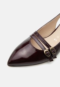 Ballerine brillante bordeaux foncé à bout pointu avec deux fines brides et boucles ovales en laiton, intérieur beige, taille indiquée 4½.