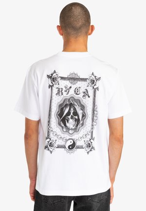 White cotton t-shirt featuring a large black graphic on the back, depicting a skull, roses, and yin-yang design within a decorative border.