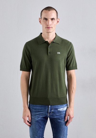 Πράσινο κοντομάνικο polo shirt από πλεκτό ύφασμα, με κολάρο και μικρό λογότυπο στην αριστερή πλευρά του στήθους. Φορεμένο με μπλε τζιν.