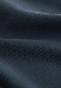 Tissu bleu foncé, texture lisse, légèrement extensible. Présente un motif de tricot fin et régulier avec un léger éclat et sans motifs ni designs visibles.