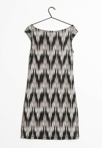 Robe sans manches, ajustée, avec un motif géométrique noir, gris et blanc. Fabriquée en tissu léger, avec un décolleté en scoop et des coutures sur les côtés.
