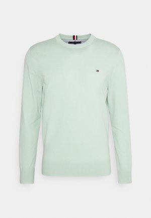 Pull en tricot vert clair avec des manches longues, col rond et petit logo brodé sur la poitrine. Texture lisse et coupe ajustée.