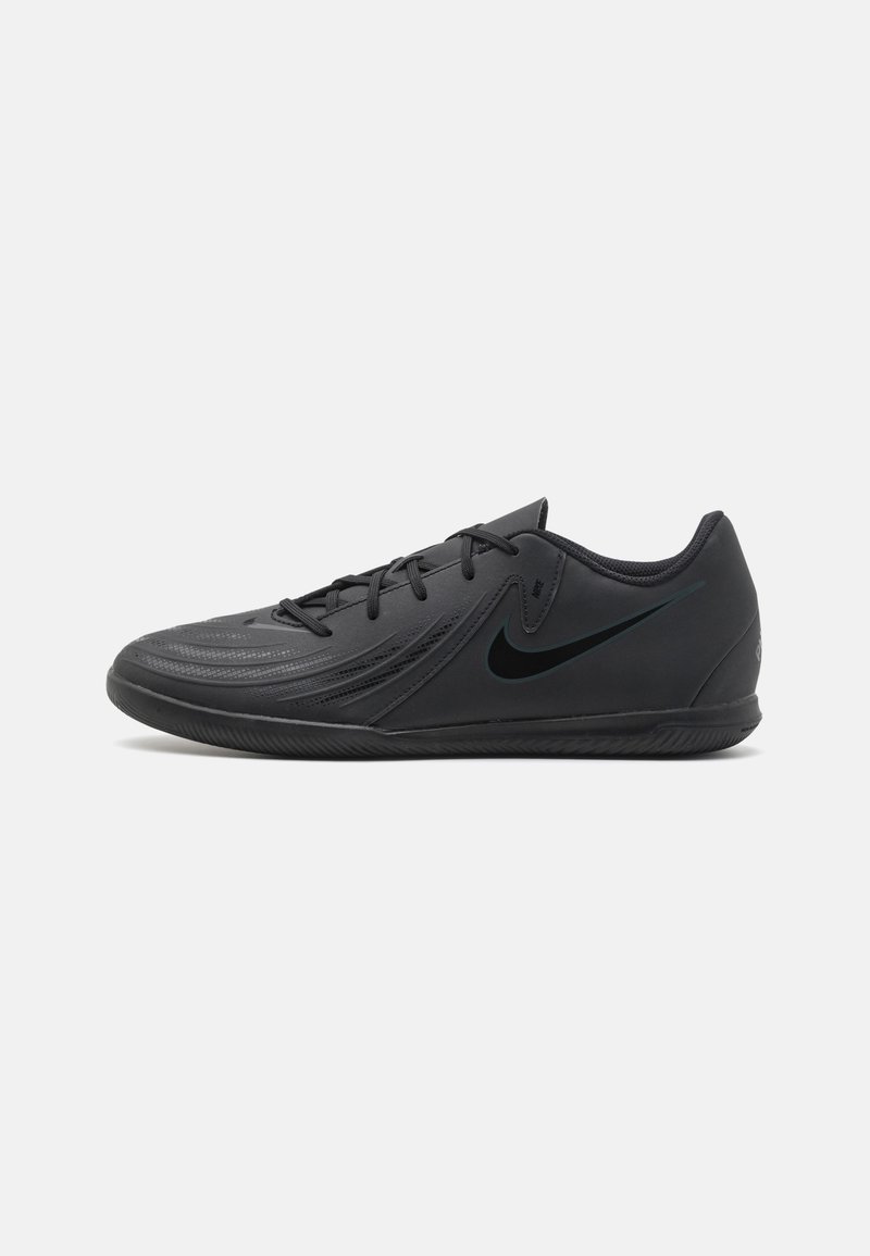 Fekete sportcipő sima szintetikus upperrel, textúrázott díszítésekkel, fűzős kivitelben és gumitalppal. Jellemzője a sötét színű Nike logó.
