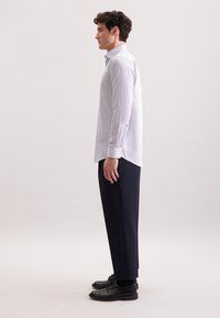 Camicia button-up a righe blu chiaro e bianche, maniche lunghe, abbinata a pantaloni blu navy scuri e scarpe stringate nere. Design semplice e classico.