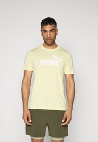 Yellow short-sleeve t-shirt made of soft material featuring a prominent white "PUMA" logo and a cat emblem on the front.