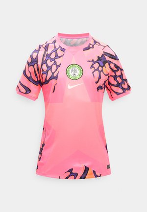 Rozā Nike futbola krekls ar Nigērijas Futbola federācijas logotipu, violeta un oranža abstrakta raksta uz pleciem un piedurknēm.