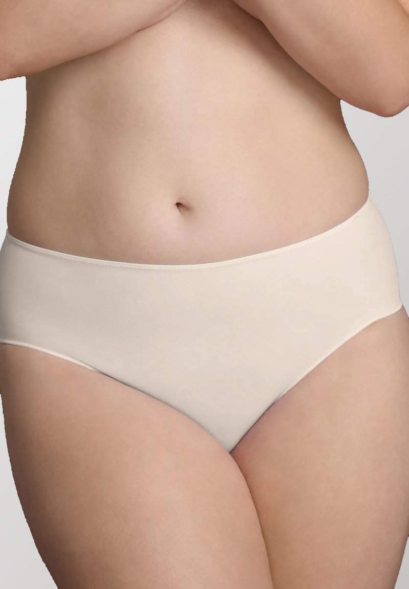 Slip beige chiaro senza cuciture, con una texture morbida, vita a media altezza e senza elastico visibile sulle gambe, progettati per il comfort e una vestibilità pulita.