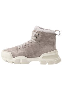 Bottines en daim gris clair avec doublure en fausse fourrure blanche, dotées de lacets et d'une semelle en caoutchouc blanche épaisse pour l'adhérence.