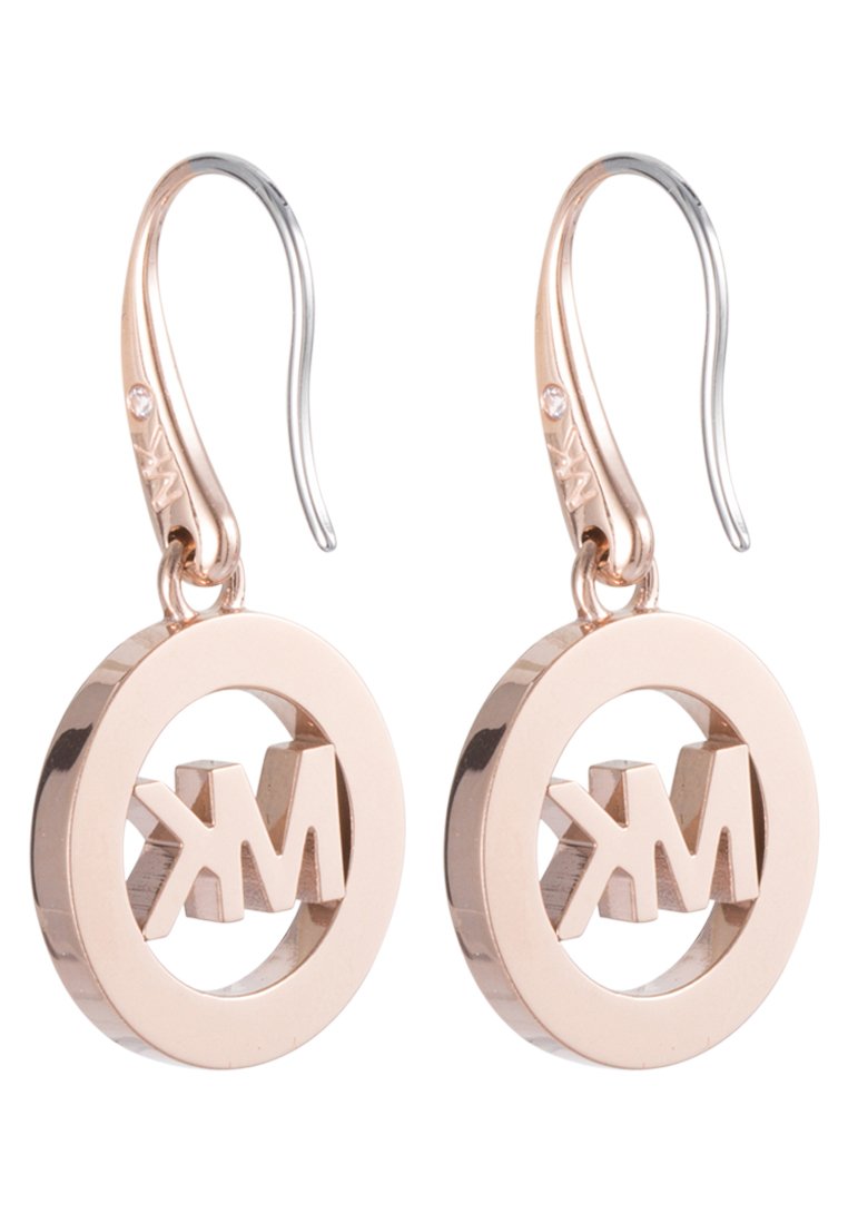 Boucles d'oreilles en or rose avec un design circulaire présentant un logo "MK" découpé, accentuées par un crochet en argent et un petit détail en cristal.
