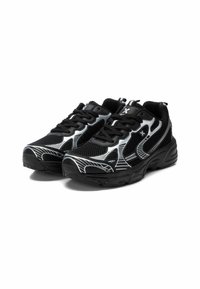 Zapatos deportivos negros con materiales de malla y sintéticos, con líneas de acento blancas, puntera redondeada y suela texturizada para agarre.