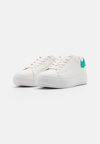 Sneakers in pelle bianca con punta tonda, suola piatta e lacci tonalità. Presentano un accento verde sul tallone e leggere perforazioni.