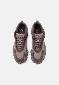 Smeđe atletske tenisice s kombinacijom mrežastog i ante materijala, s teksturiranim potplatima, pletenicama za vezanje i dva povlačna tablica na peti.