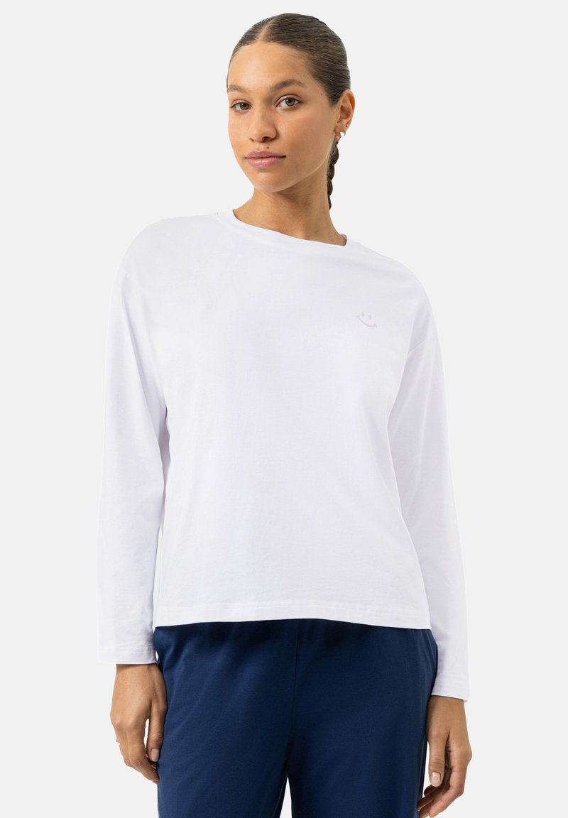 Witte lange mouw katoenen t-shirt met een ronde halslijn en een subtiel lichtroze smiley gezicht logo op de borst.