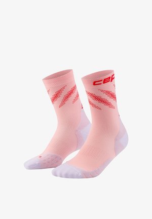Pair of pink athletic socks with white toes and heels, featuring red diagonal patterns and red text near the cuffs.