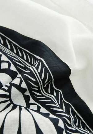 Black and white patterned fabric with a smooth texture, featuring stylized botanical designs on a light background.