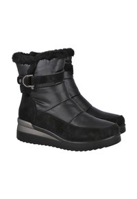 Un par de botas de invierno negras con forro de piel sintética, parte superior acolchada, acentos de ante y un cinturón lateral sobre suelas de cuña de goma negra.