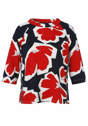 Chemise manches trois-quarts avec des motifs floraux rouges et blancs audacieux sur un fond noir et un col rond.