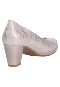 Chaussure à talon haut métallisée rose avec une texture à motifs, bout arrondi et talon épais. Présente une petite découpe près de l'orteil.