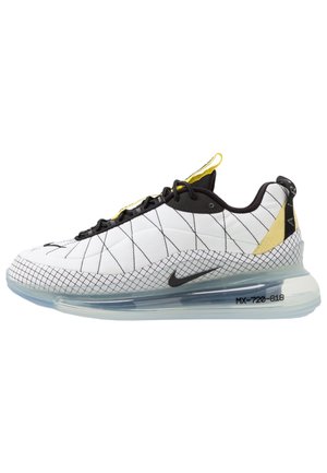 Baskets Nike avec un revêtement supérieur texturé blanc, un motif de grille noire, des accents jaunes et une semelle transparente avec une unité air visible.