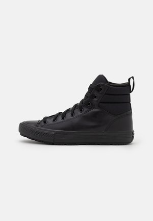 Baskets montantes noires avec un extérieur en cuir lisse, des accents texturés, un bout rond, un design à lacer et un col rembourré pour le soutien.