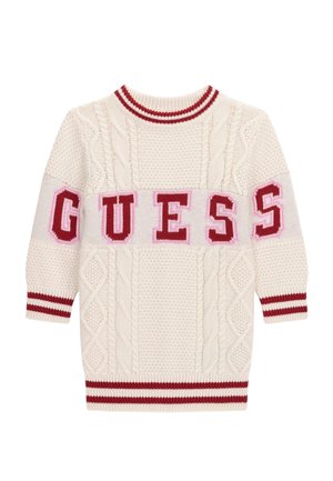 Kremowy sweter z dzianiny z wzorami warkoczy, czerwono-białe paski na kołnierzu i mankietach oraz napis "GUESS" dużymi czerwonymi literami na przodzie i rękawach.
