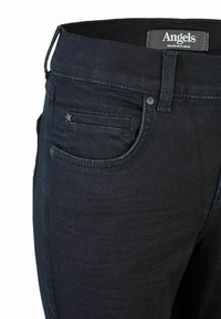 Donkerdenim jeans met een fitted ontwerp, met een steraccent op de voorzak. De stof heeft een subtiele glans en een gladde structuur.