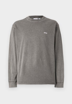 Long-sleeve gray cotton t-shirt featuring a crew neck, relaxed fit, and small white "obey" logo on the left chest. Soft texture.