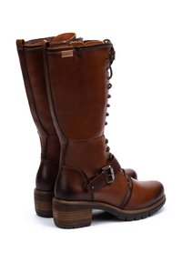 Bottines en cuir marron à lacets, hauteur mollet, avec boucle latérale, talons empilés et semelles en caoutchouc robustes, présentées de profil sur fond blanc.