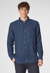 Camicia in lino blu navy con maniche lunghe, colletto button-down e piccolo logo ricamato in rosso sul lato sinistro del petto. Presenta bottoni bianchi.
