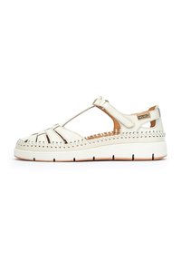Sandalias de piel blanca con diseño recortado, acentos marrones en contraste, bordes cosidos y suela de goma. Correa ajustable para un ajuste seguro.