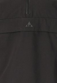Tissu noir avec une texture lisse ; présente une courte fermeture éclair en haut et un logo avec des accents triangulaires embossés en dessous.