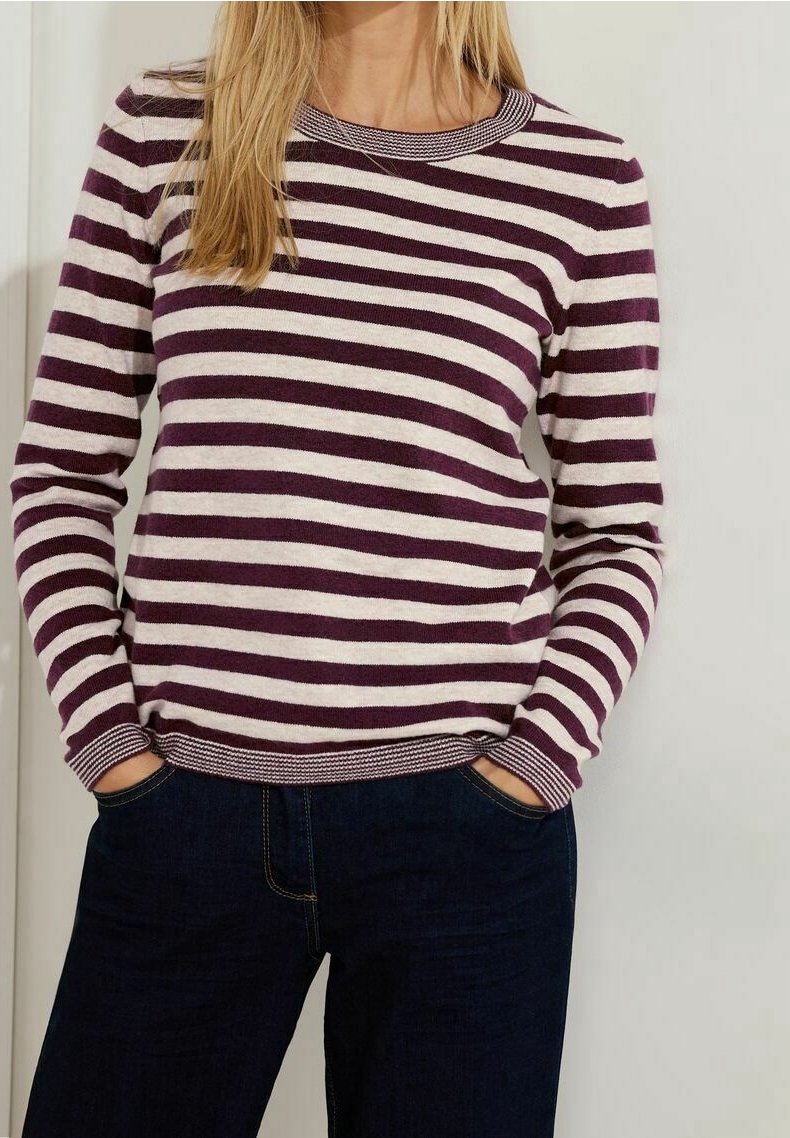 Gestreifter Pullover in Dunkellila und Creme. Mit Rundhalsausschnitt und gerippten Bündchen, kombiniert mit dunklen Jeans. Glatte Textur.