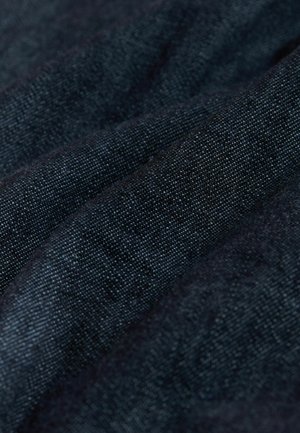 Nahaufnahme von dunkelblauem strukturiertem Stoff mit sichtbarer Webart und weichen Falten.
