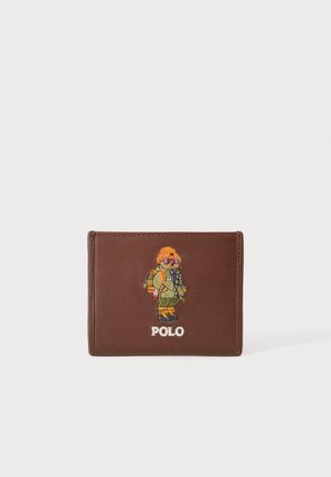 Hnedá kožená peňaženka s vyšitou postavou osoby v zimnom oblečení a slovom "POLO" pod ňou.