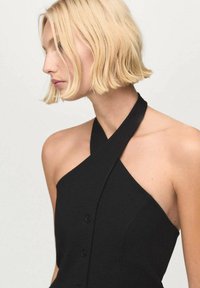 Black halter-neck dress made of smooth fabric with buttons down the front; features a fitted silhouette and wide shoulder strap design.