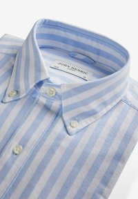 Vaaleansininen ja valkoinen raidallinen kauluspaita, jossa on napitettavat kaulukset, pieniä valkoisia nappeja ja tekstiilitaittelu. Labelissa lukee "John Henric."