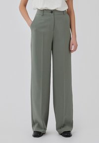 Wide-leg trousers in olive green, made of smooth fabric. Features a front button closure and side pockets. Tailored fit, with a clean design.