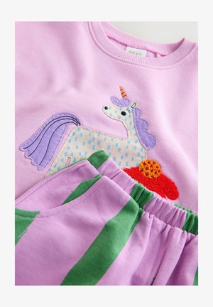 Sudadera rosa con una aplicación de unicornio; incluye acentos en púrpura y naranja. Pantalones de pijama lavanda con rayas verdes y cinturilla elástica.