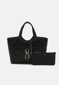 Sac à main noir matelassé avec double poignée et pendentif en argent attaché, accompagné d'une pochette zippée matelassée assortie.