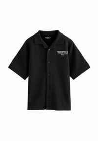 Camisa negra de manga corta hecha de una tela suave; cuenta con un cierre de botones en la parte delantera y un cuello con texto blanco que detalla 'Tokyo District, JP'.