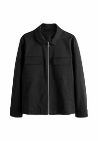 Veste noire avec fermeture éclair à l'avant, col et deux poches poitrine. Fabriquée en tissu lisse, à manches longues et avec une coupe décontractée.