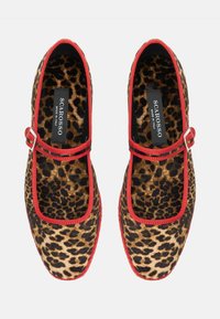Buty w panterkę z czerwonymi wykończeniami i detalem z klamrą. Wykonane z tkaniny, z okrągłym noskiem i płaską podeszwą. Widoczna etykieta "SCAROSSO".
