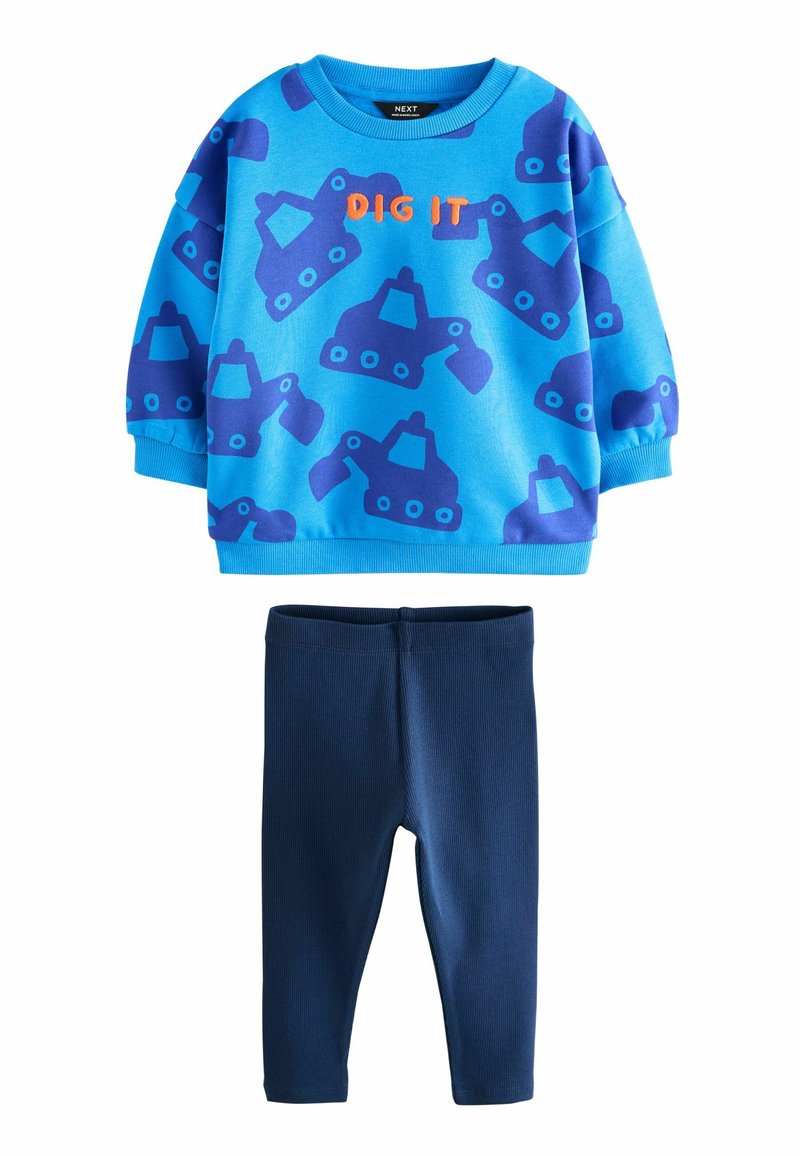 Blå sweatshirt med lilla gravemaskine-mønster og orange "DIG IT" tekst, parret med mørkeblå leggings i et glat, strækbart stof.