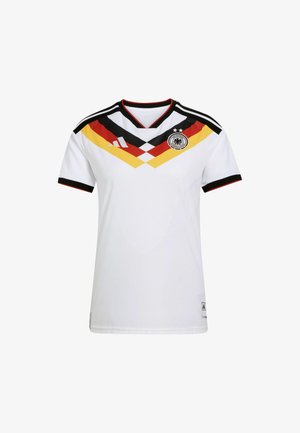 Witte voetbaltrui met zwart en gekleurd chevronontwerp (zwart, rood, geel) op de borst; voorzien van een V-hals en logo aan de linkerkant.